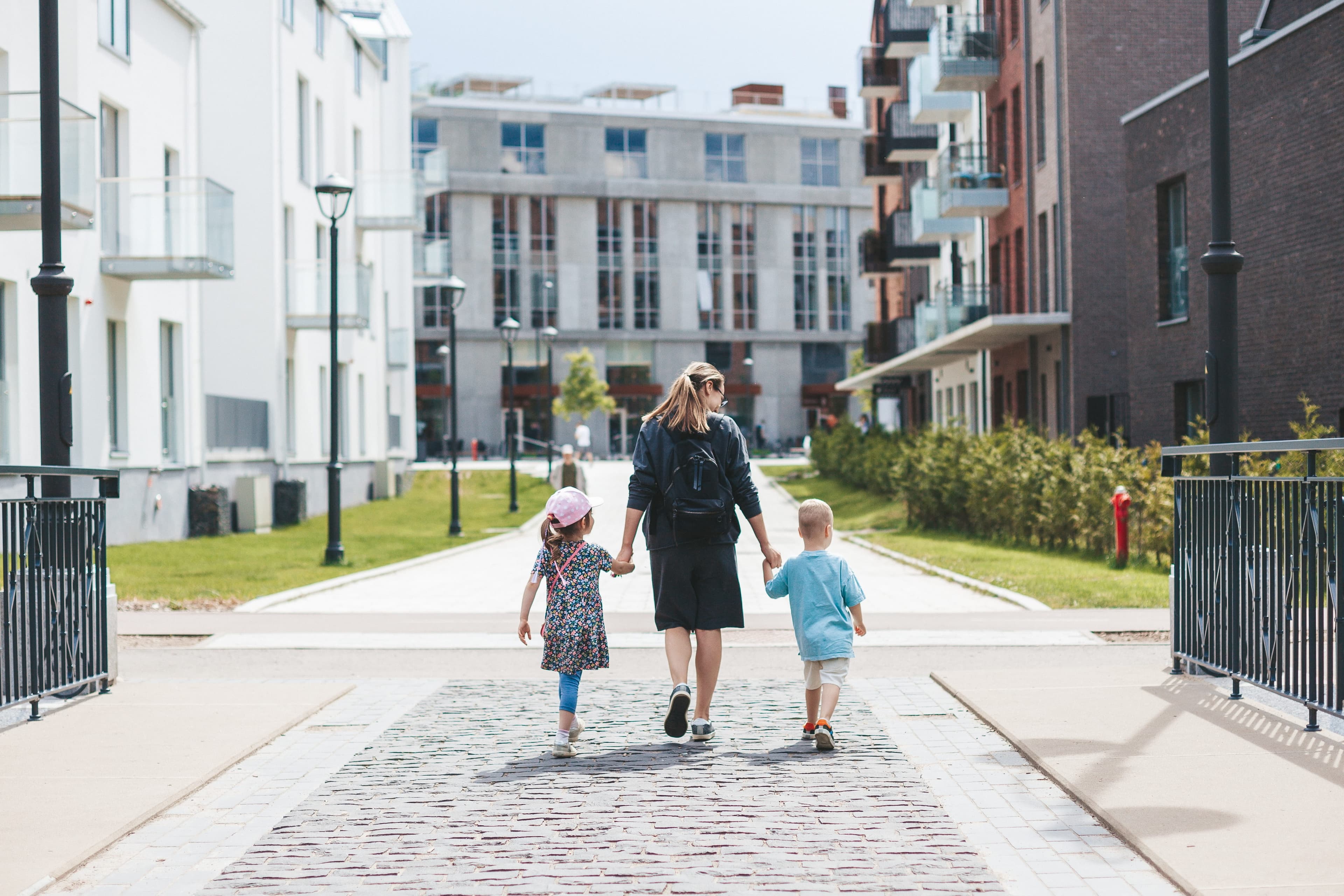 Housing Associations — young mother with two kids walking around the city (funding)